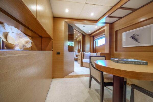 The dining area of ​​the Silent World yacht with warm wood paneling and custom furniture
