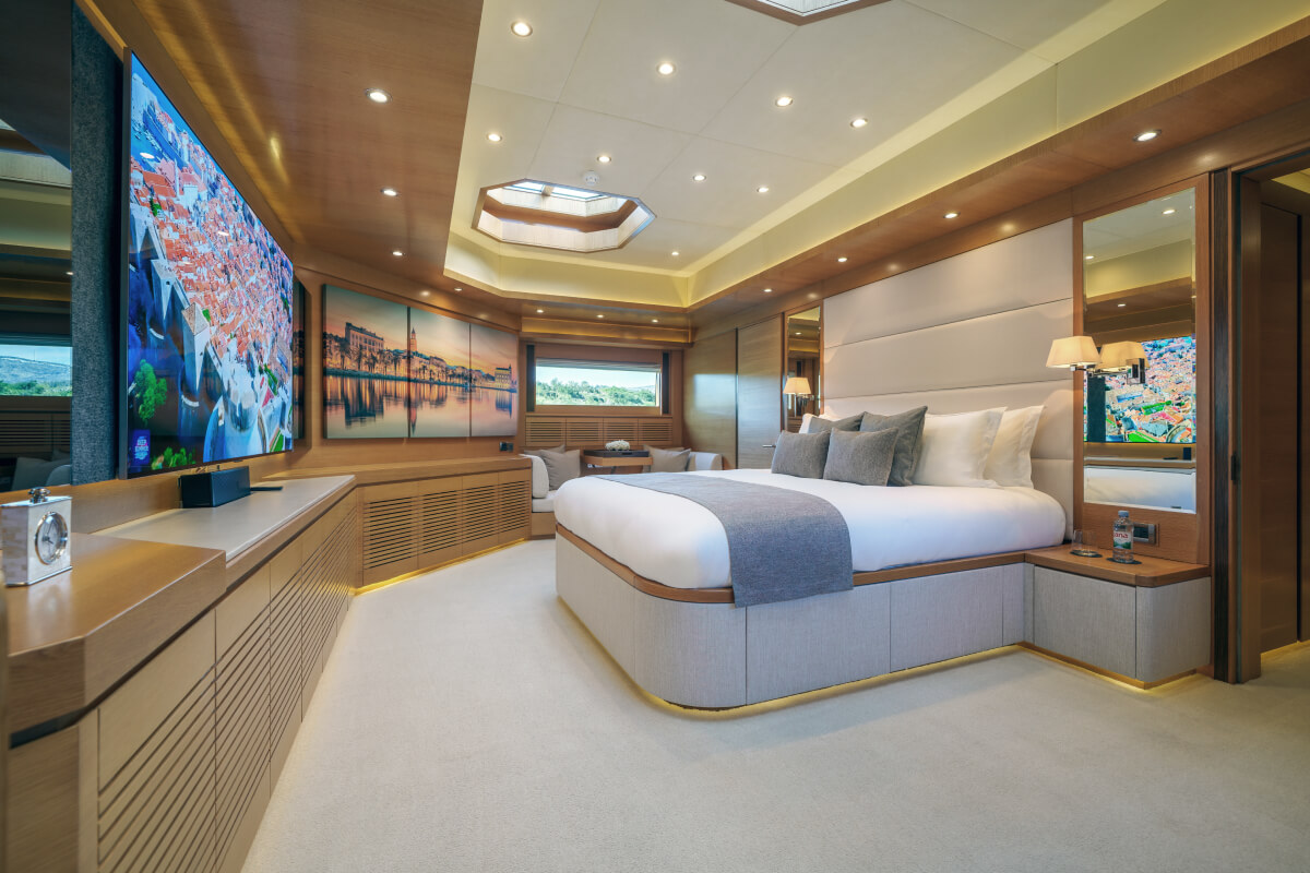 The master cabin of a luxury yacht with a large bed and wooden details